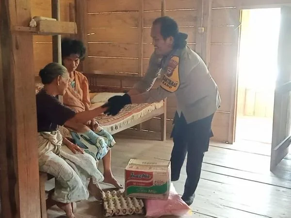 Bhabinkamtibmas Polsek Bonggakaradeng Polres Tana Toraja saat memberikan bantuan kepada warga kurang mampu (Dok : ist).