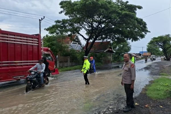 Personel Polsek Bangkala dan Pos Pengamanan (Pos Pam) Operasi Lilin Pallawa 2024, serta personil Samapta Polres Jeneponto saat mengatur arus lalu lintas di Ruas Jalan Poros Jeneponto-Makassar (Dok : Ist).