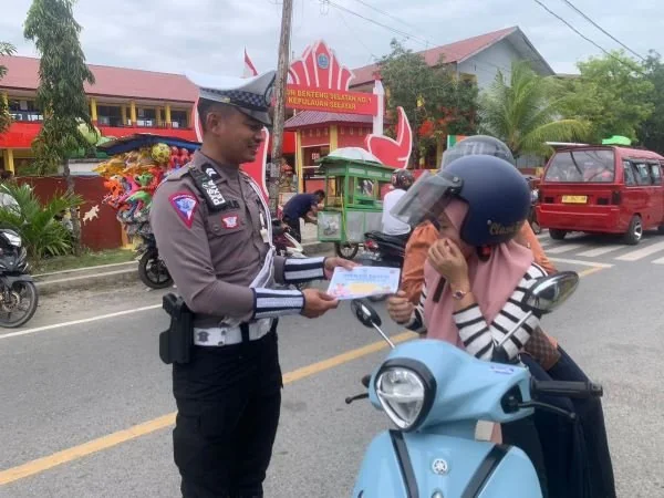 Anggota kepolisian membagikan brosur Ops Patuh Pallawa 2024 di Kepulauan Selayar (Dok : ist).