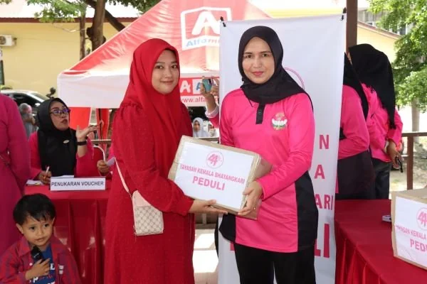 Ketua Bhayangkari Cabang Jeneponto, Ny. Rini Budi Hidayat saat serahkan paket sembako ke salah seorang warga.
