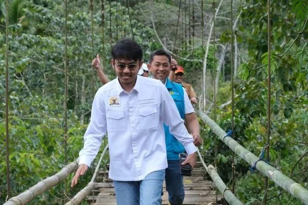 Anggota DPR RI Komisi VI, Ismail Bachtiar (kiri) dan GM PLN UID Sulselbar, Edyansyah (kanan) saat melewati jembatan meresmikan nyala listrik Kampung Menra, Kabupaten Sinjai (Dok : Ist).