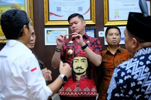 Bupati Gowa saat mengecek perbedaan uang palsu dan asli (Dok : Ist).