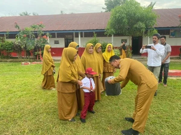 Kadis Pendidikan Sulbar saat menyerahkan bantuan kepada Firdaus di SD Inpres Kuo (Dok : ist).