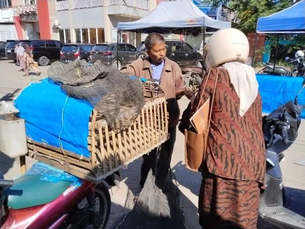 Salah satu pedagang ayam kampung di pasar sentral Takalar saat melayani pembeli (Dok : Saleh KabarMakassar).