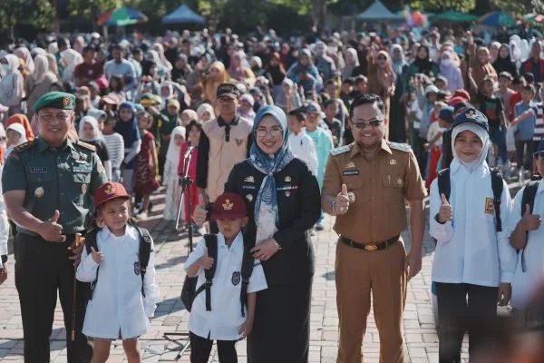 Bupati Gowa, Sitti Husniah Talenrang dan Wakil Bupati Gowa, Darmawangsyah Muin saat memberikan  seragam sekolah gratis bagi siswa baru SD dan SMP (Dok : Ist).