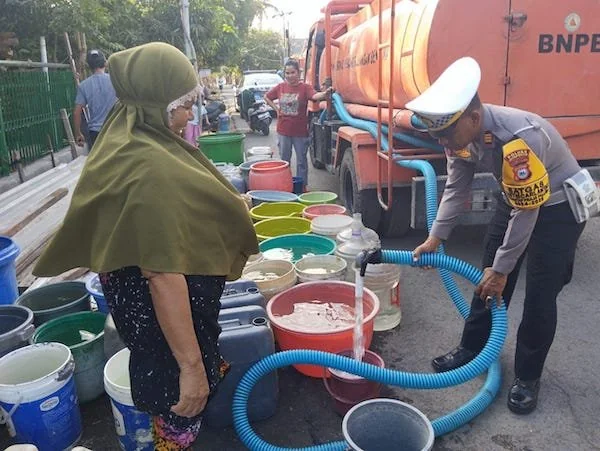Kasat Lantas AKP  Abdul Samad saat melakukan pendistribusian air bersih ke warga Dusun Embo. (Foto/ist).